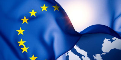 Bandiera europea che sventola sul continente, visual simbolico della riforma della politica di coesione UE e del suo ruolo nel bilancio post-2027.